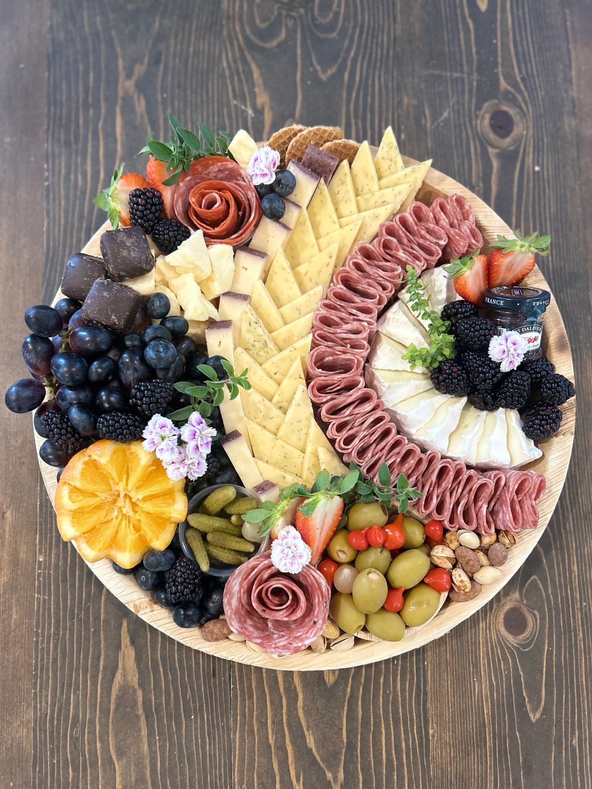 Round charcuterie board with blackberries and brie